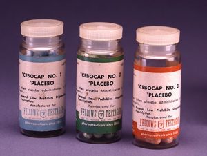This image shows three medicine bottles lined up next to one another. Each bottle contains a different colored label and each contains the word placebo on the front.