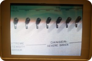 This is an image of Milgram’s shock panel. There are seven knobs visible on the panel. The left-hand side is labeled extreme intensity shock, and the right-hand side is labeled danger severe shock. The voltages are listed above the knobs.