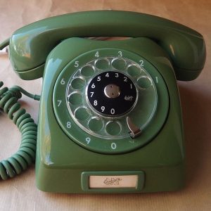 This is an image of a green, rotary desk phone.