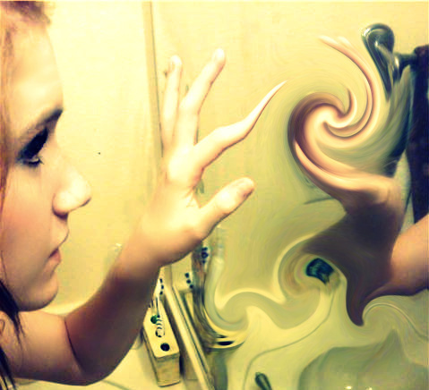 This image shows the profile of an adolescent girl facing a wall while placing her left hand up against a mirror. Her pointer finger is skewed and longer than it should be, and the reflection in the mirror is distorted.
