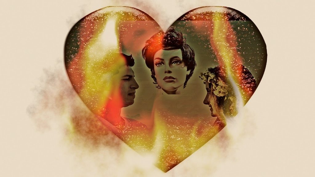 This is a color image of three people's faces within the shape of a heart. There is a male located on the left, and he is looking forward to a woman to his right. In the top center of the heart is a second woman with a solemn look on her face. There are flames covering part of the heart.